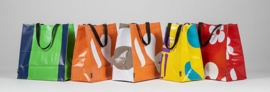 Five colorful tote bags on a white surface with a light gray background